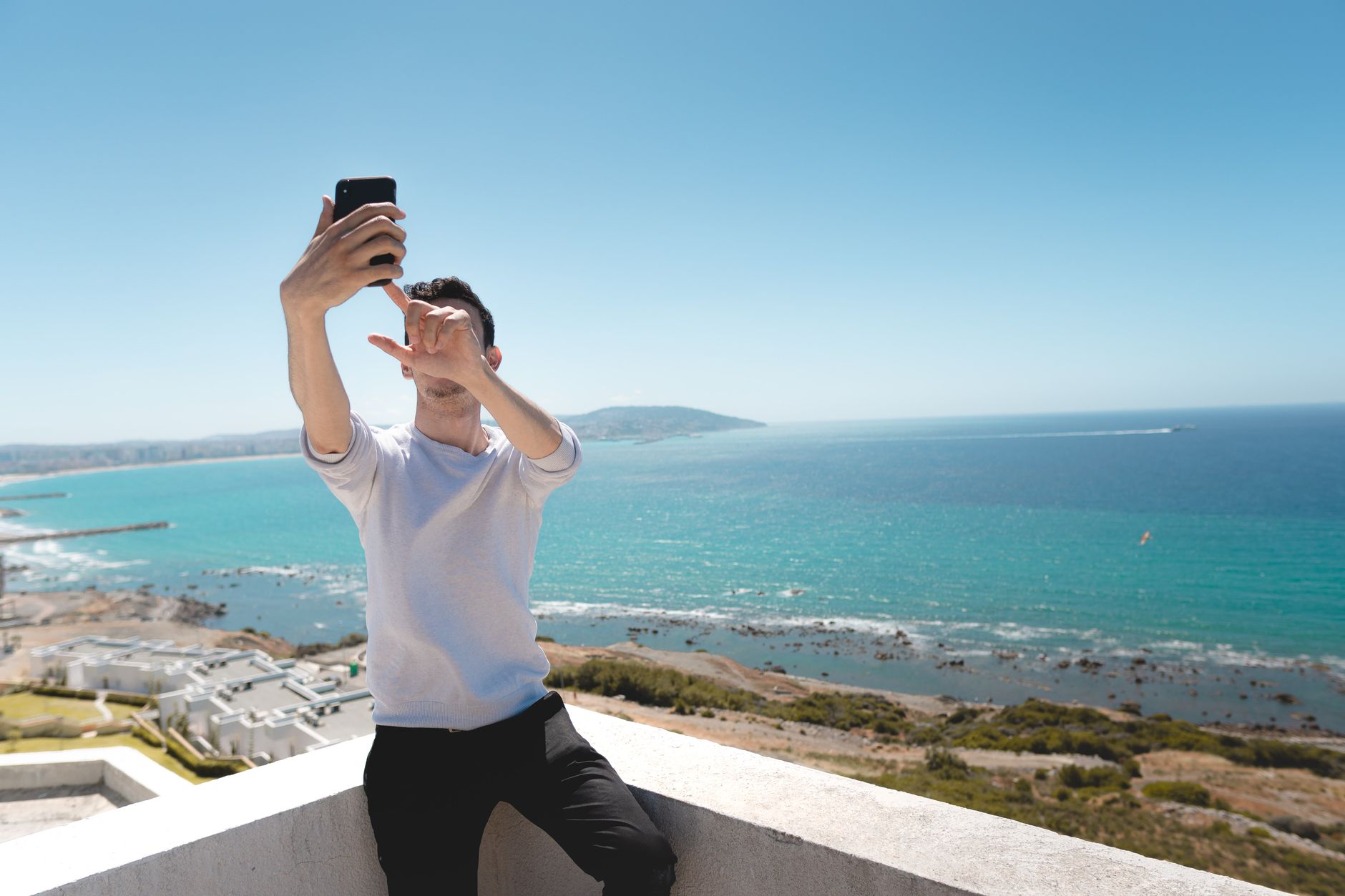 Matériel malin pour se prendre en photo seul avec smartphone, iPhone ou appareil photo — personne prenant un selfie en extérieur avec smartphone